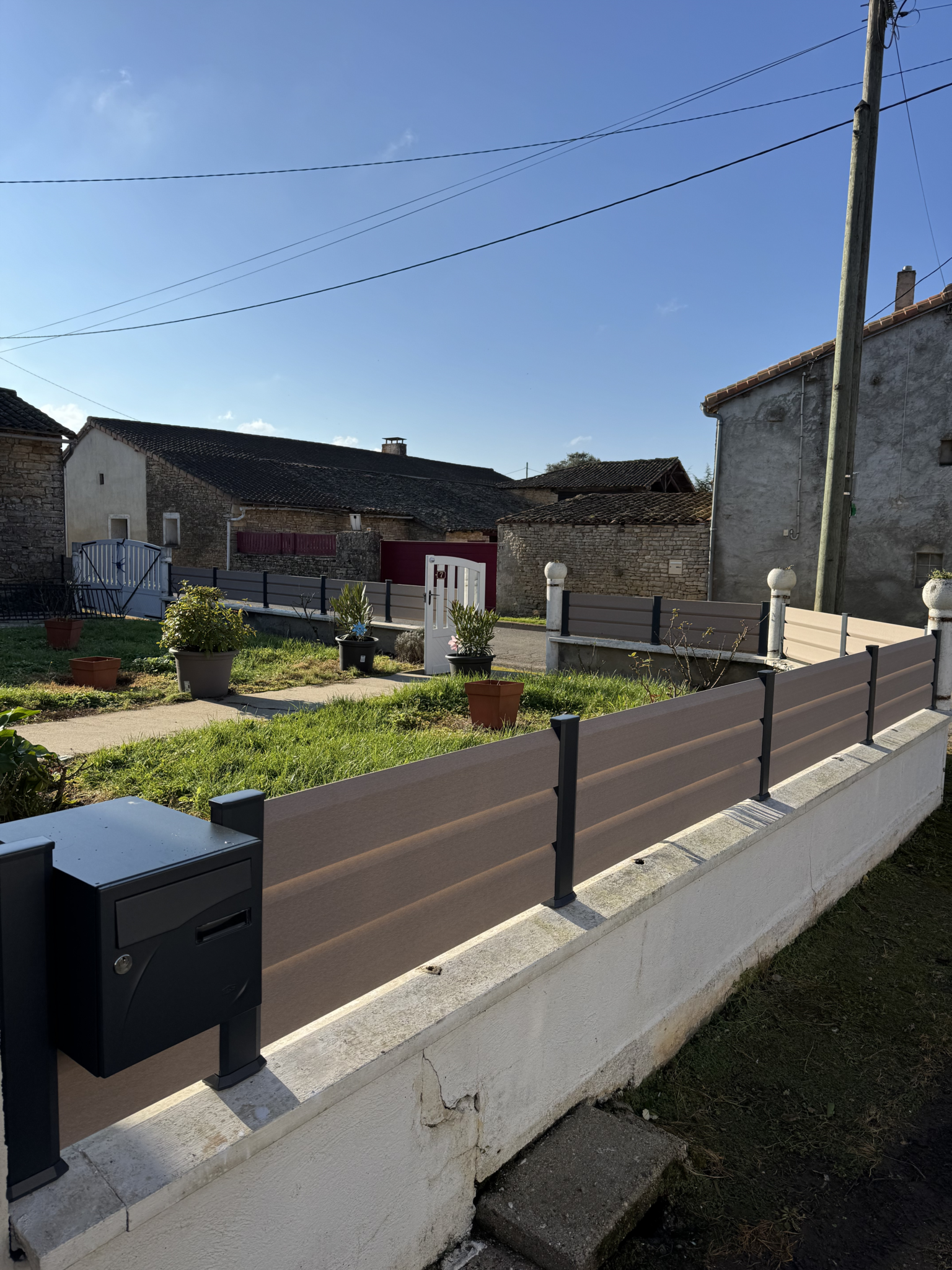Nouvelle clôture PVC Cloryza avec poteaux gris anthracite sur muret