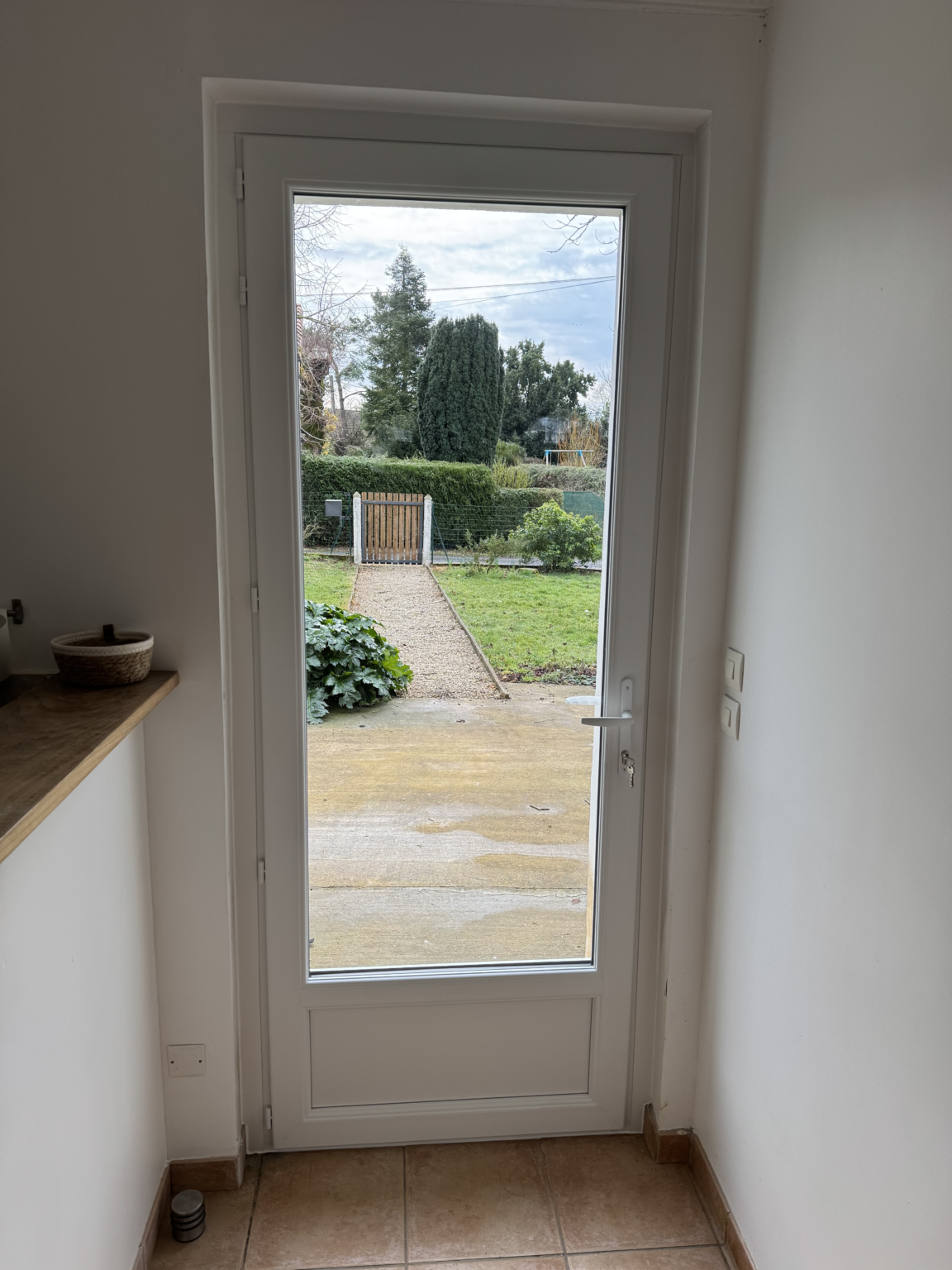 Nouvelle porte d’entrée vitrée en PVC blanc vue de l’intérieur