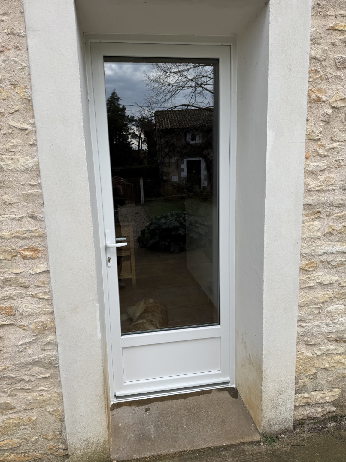 Nouvelle porte d’entrée vitrée en PVC blanc vue de l’extérieur