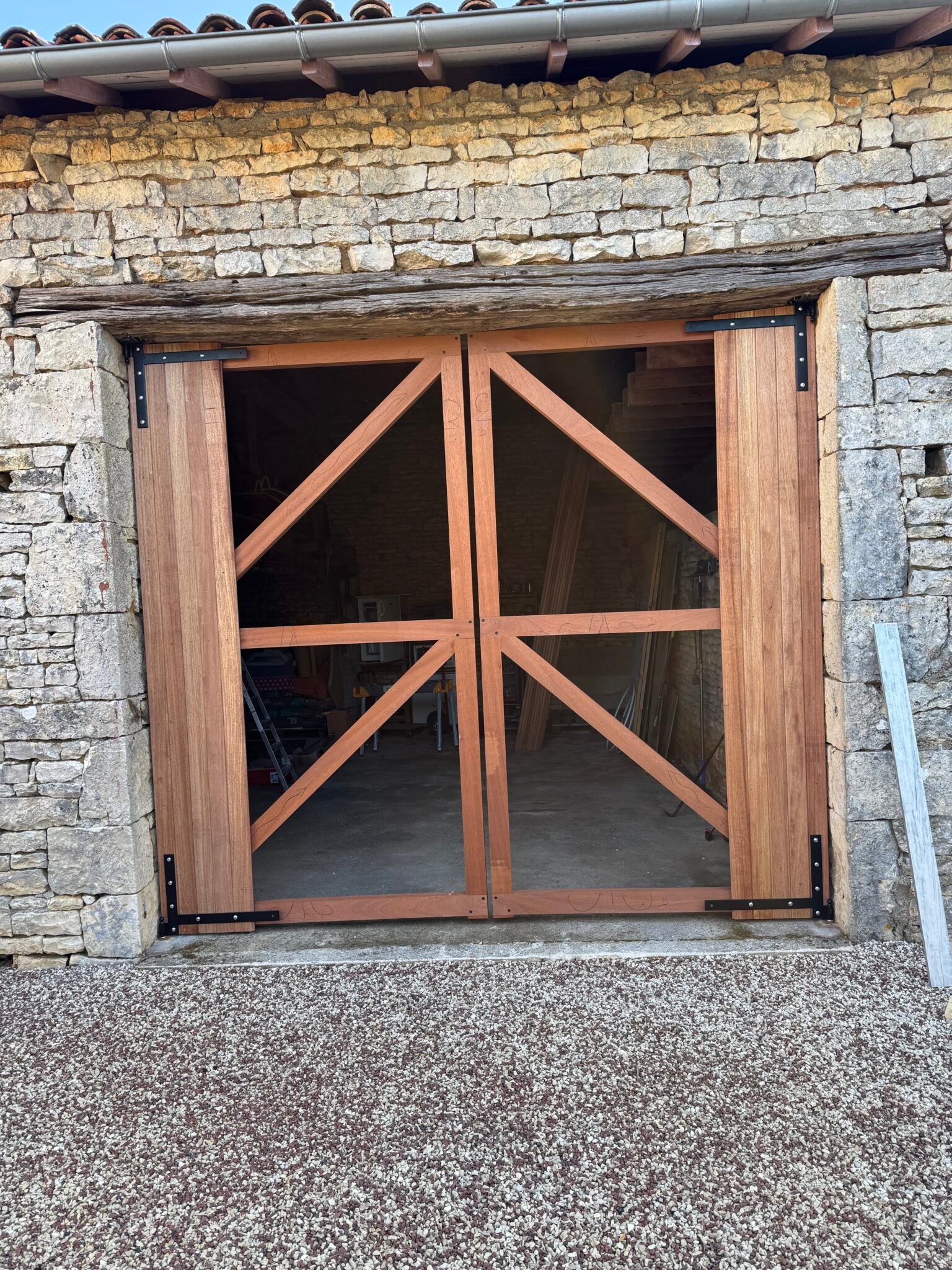 Pose de la structure d’une porte de grange en bois exotique sur mesure