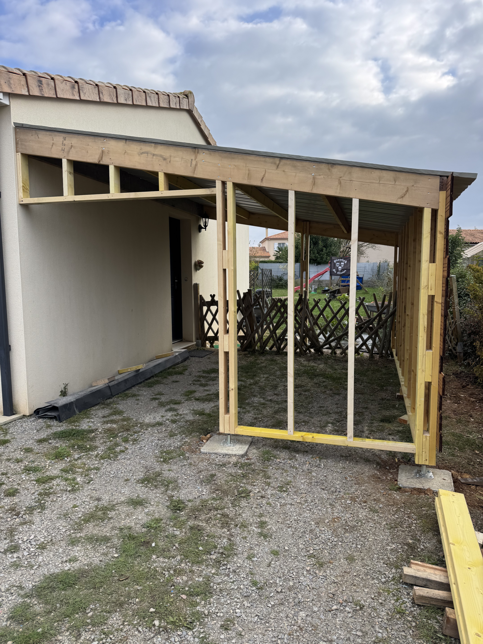 Pose de l’ossature et du bardage d’un carport en bois
