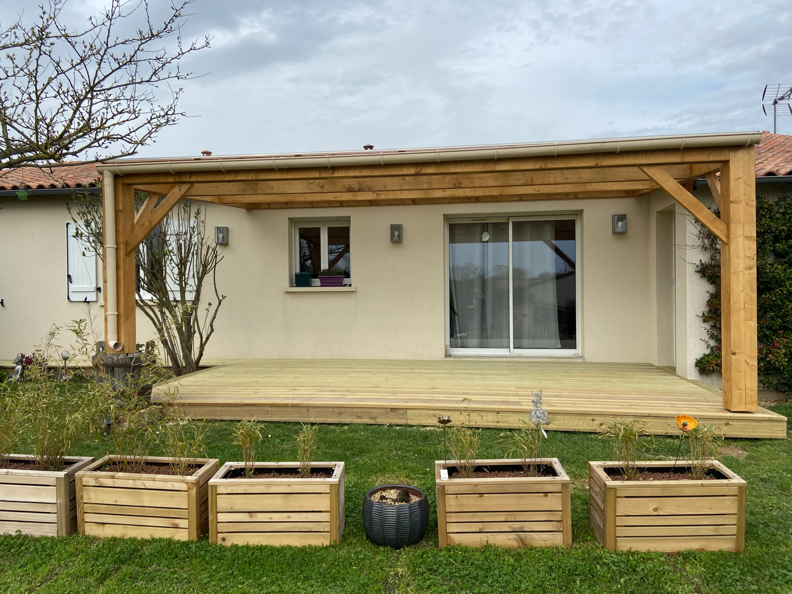 Terrasse en bois avec pergola adossée et toiture translucide