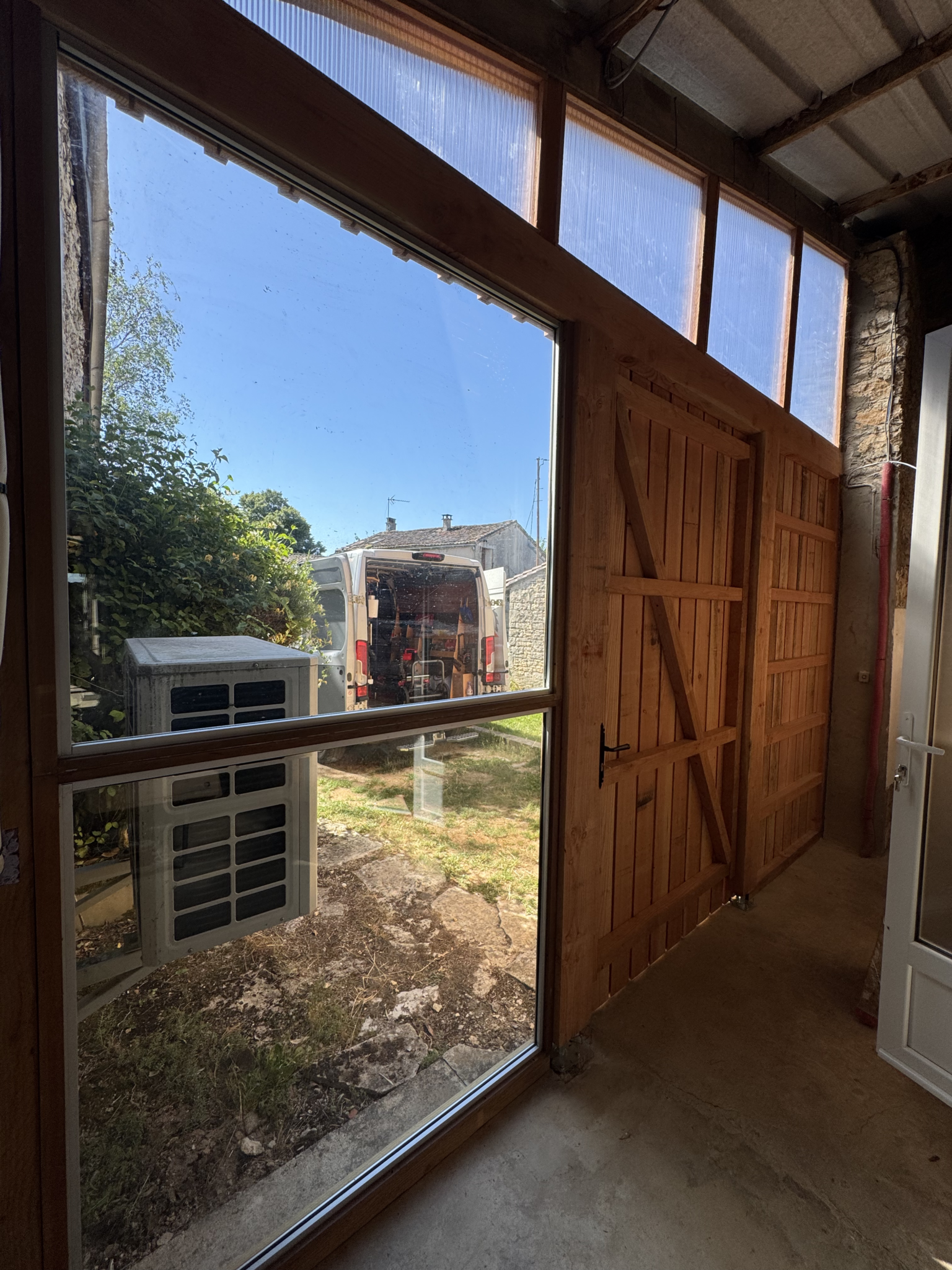 Vue intérieure d’une façade en bois avec porte de grange et partie vitrée