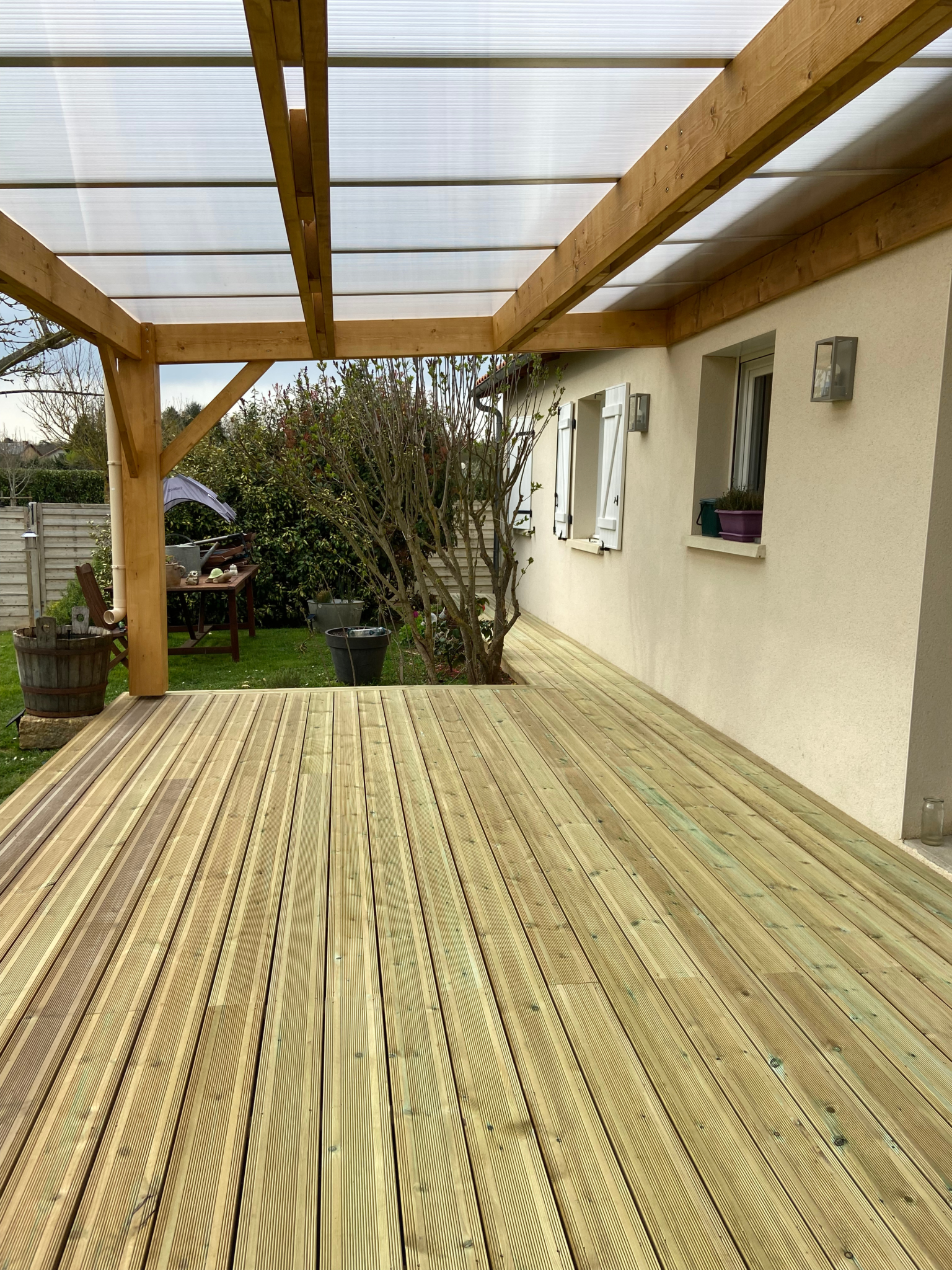 Vue intérieure d’une pergola en bois avec couverture translucide